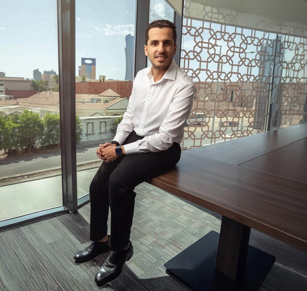 Dr. Ahmed Alghamdi, periodontist at Tam Dental, seated by the office window in Jeddah
