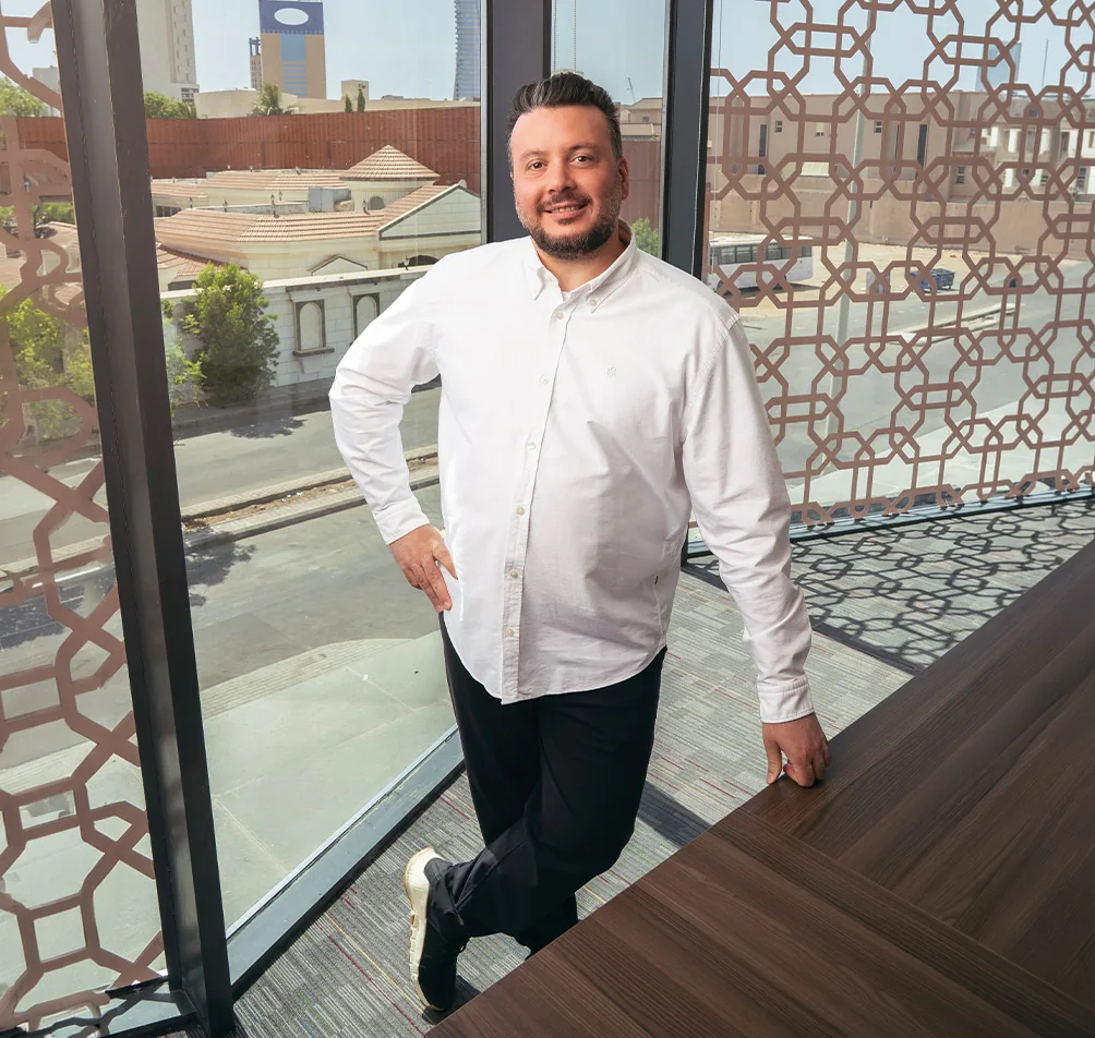 Dr. Badr Othman, implantologist at Tam Dental, standing by the office window in Jeddah
