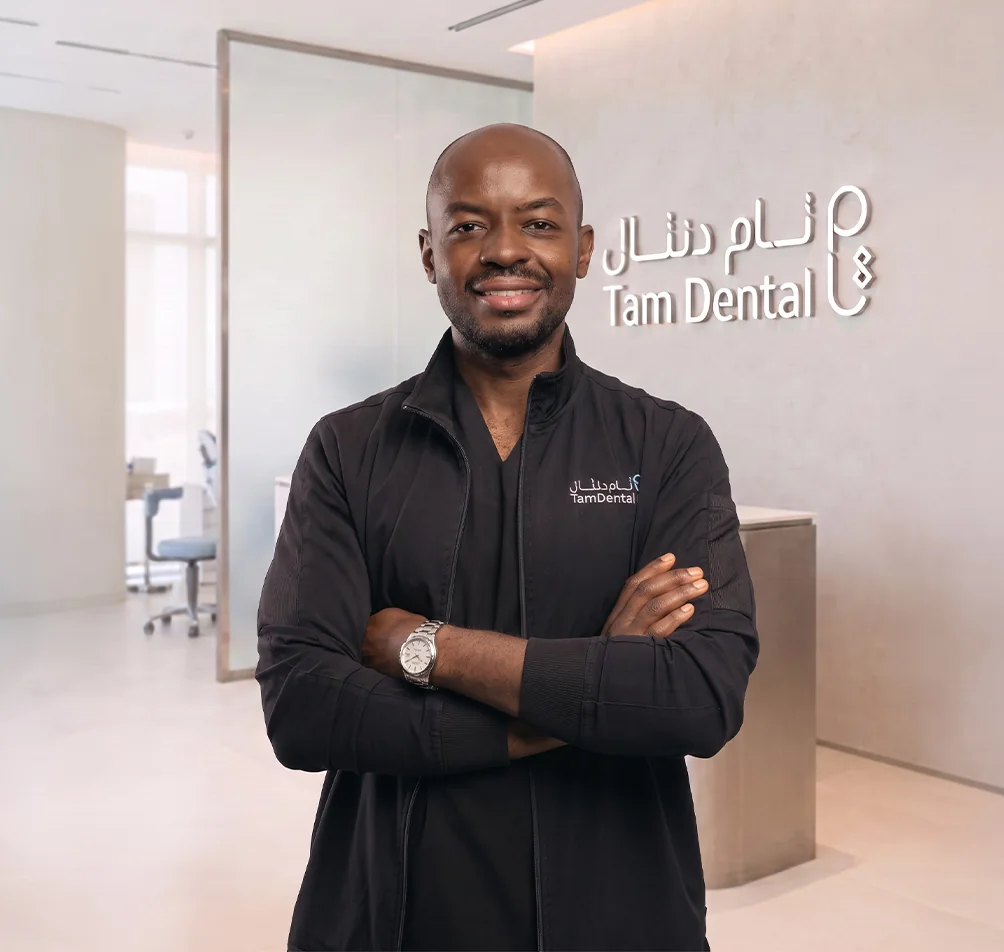 Dr. Mohammed Alharbi standing beside the Tam Dental reception sign in Jeddah