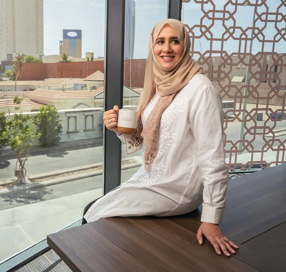 Dr. Salma Ghoneim, orthodontist at Tam Dental, sitting by the office window in Jeddah