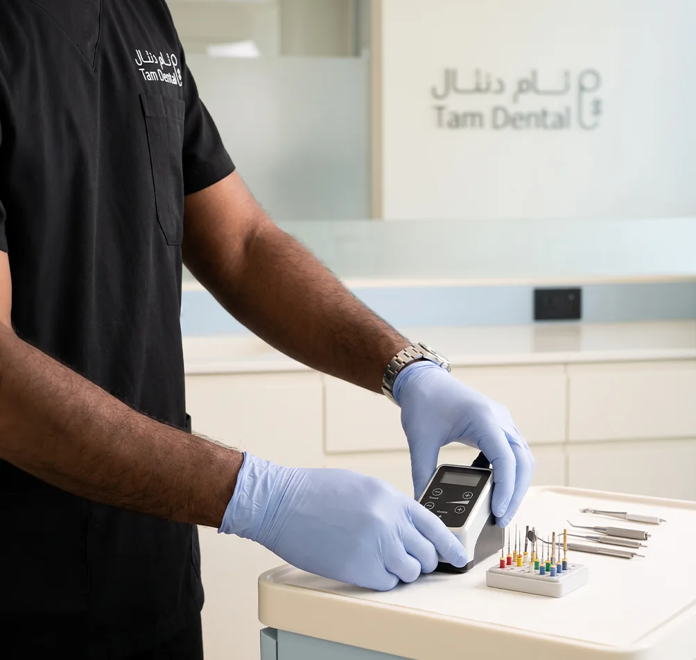 Endodontist preparing root canal files and an apex locator at Tam Dental in Jeddah