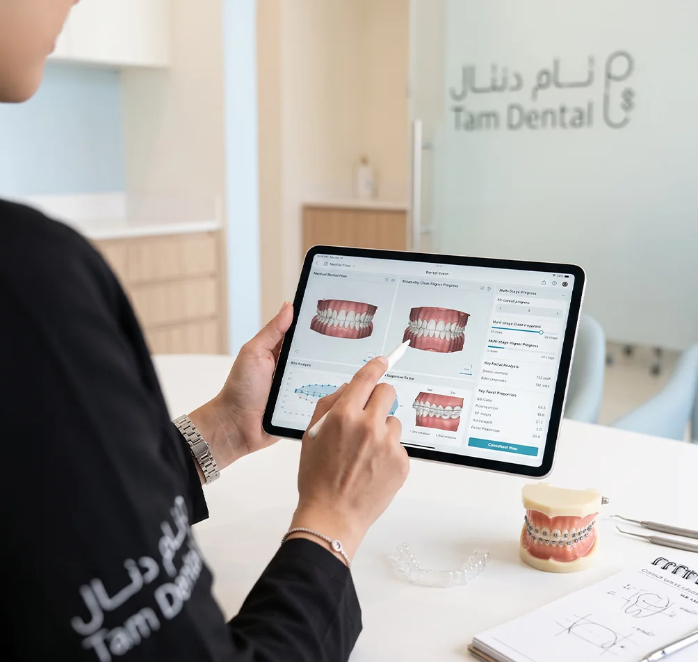 Orthodontist reviewing a braces treatment plan on a tablet at Tam Dental in Jeddah