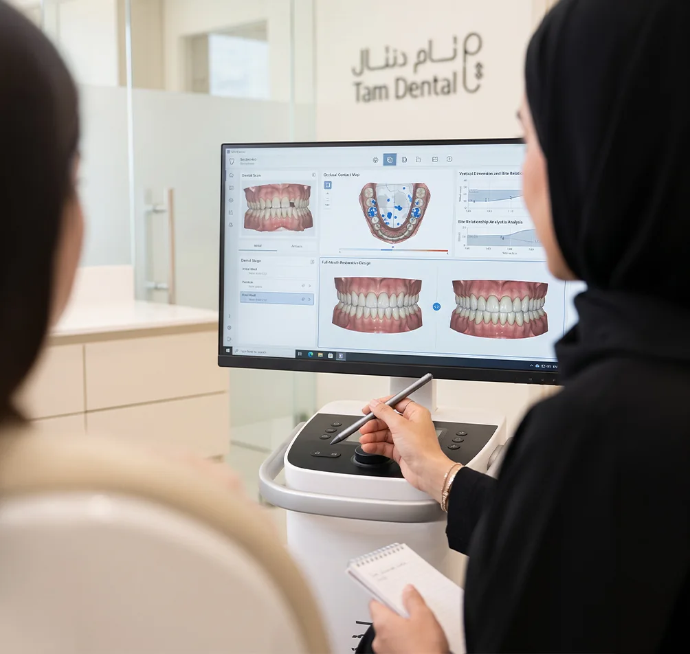 Prosthodontist reviewing a digital smile design case on screen with a colleague at Tam Dental in Jeddah