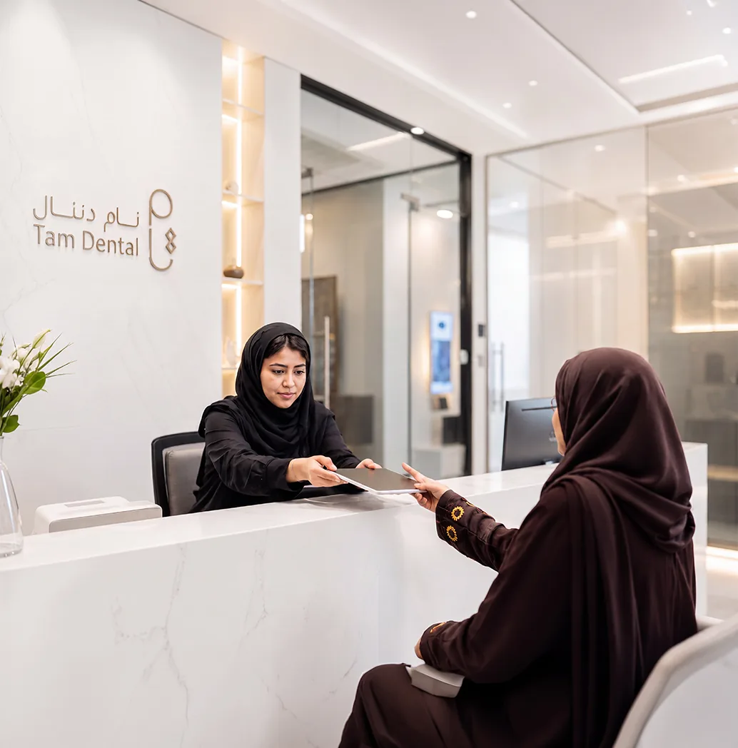 Patient checking in at the Tam Dental clinic reception desk in Jeddah